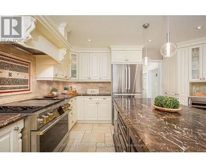 A kitchen with white cabinets and a marble countertop.