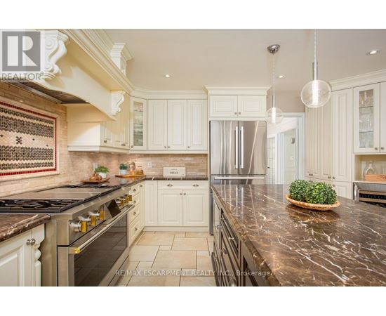 A kitchen with white cabinets and a marble countertop.