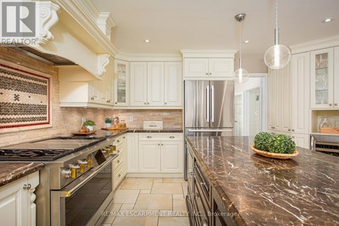 A kitchen with white cabinets and a marble countertop.
