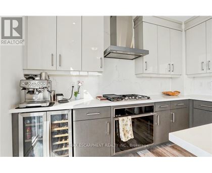 A modern kitchen with white cabinets and a stainless steel island.