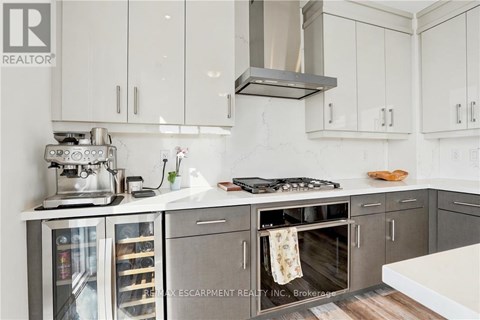 A modern kitchen with white cabinets and a stainless steel island.