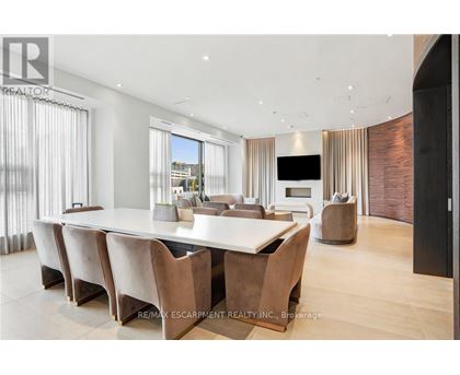 A modern dining room with a long table and chairs.