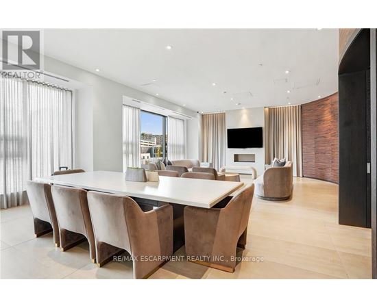 A modern dining room with a long table and chairs.