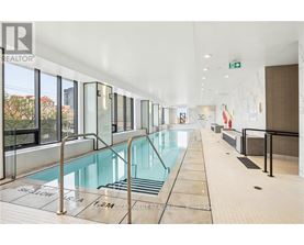 A large indoor swimming pool with a glass wall on one side.