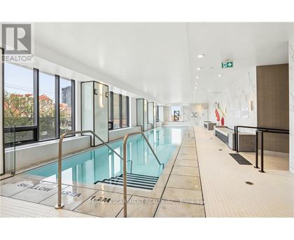 A large indoor swimming pool with a glass wall on one side.