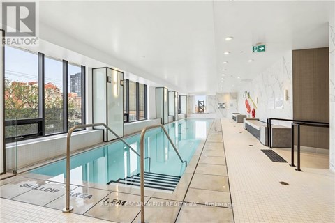 A large indoor swimming pool with a glass wall on one side.