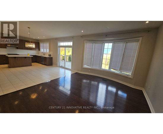 A spacious room with a wooden floor and a bar area.