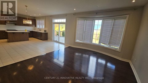 A spacious room with a wooden floor and a bar area.