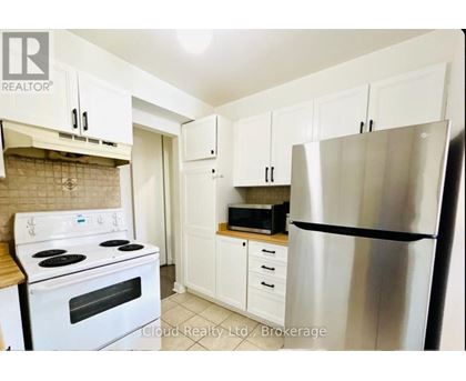 A kitchen with white cabinets and a stainless steel refrigerator.