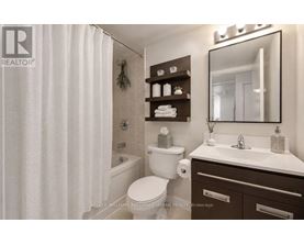 A white toilet sits in a bathroom with a white shower curtain.