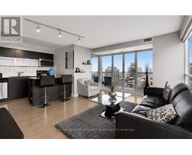 A modern living room with a kitchen area in the background.