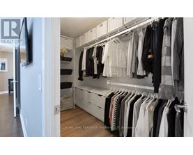 A well organized walk in closet with clothes hanging on shelves and drawers.