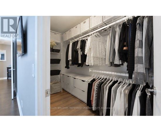 A well organized walk in closet with clothes hanging on shelves and drawers.