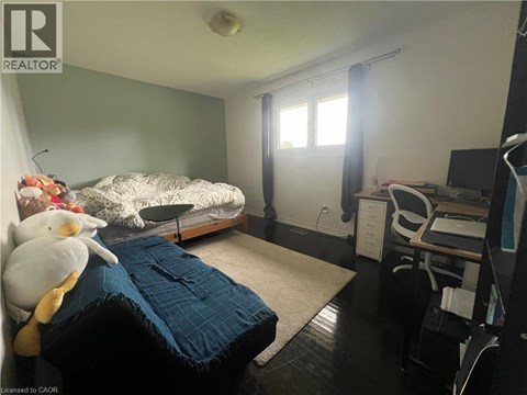 A bedroom with a bed, desk, and chair.