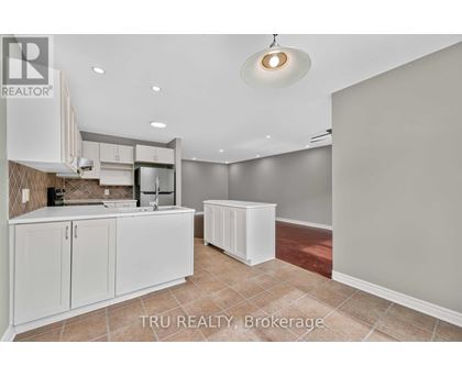 A kitchen with white cabinets and a tiled backsplash is for sale.