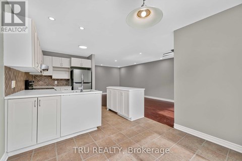 A kitchen with white cabinets and a tiled backsplash is for sale.