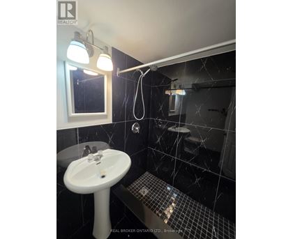 A bathroom with a sink, mirror, and tiled floor.