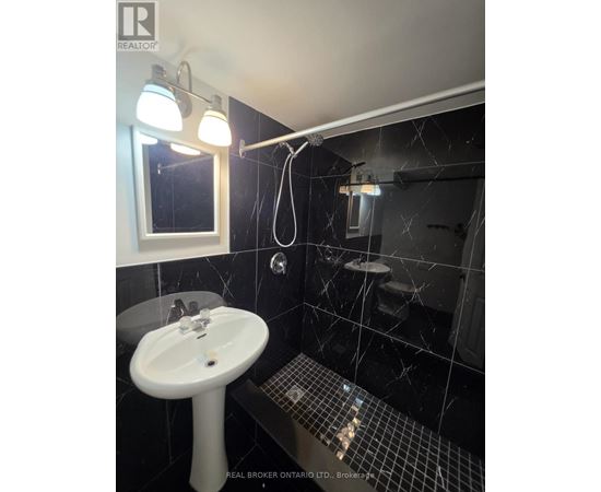 A bathroom with a sink, mirror, and tiled floor.
