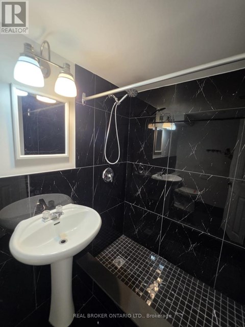 A bathroom with a sink, mirror, and tiled floor.