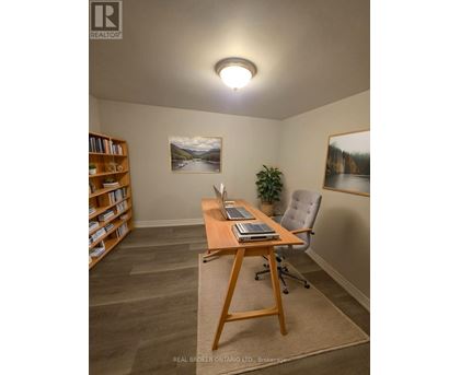 A room with a desk, chair, and bookshelf.