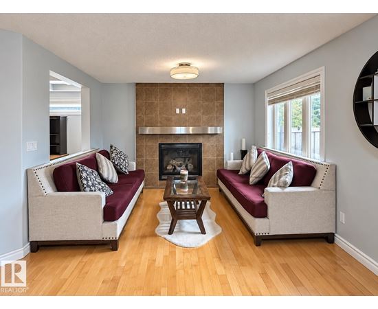 A living room with two couches and a fireplace.