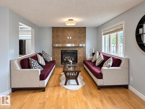 A living room with two couches and a fireplace.