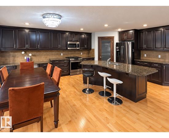 A kitchen with a table and chairs.