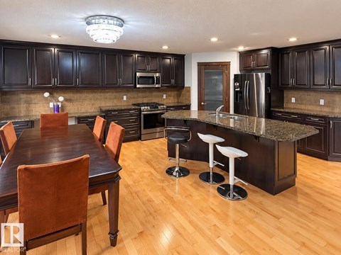 A kitchen with a table and chairs.