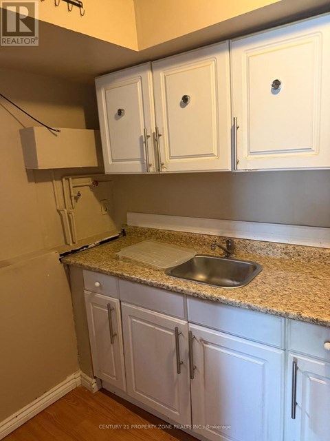 A kitchen with white cabinets and a granite countertop.