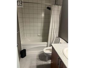 A white bathroom with a toilet, sink, and bathtub.