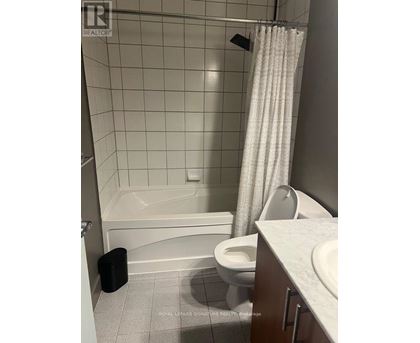 A white bathroom with a toilet, sink, and bathtub.