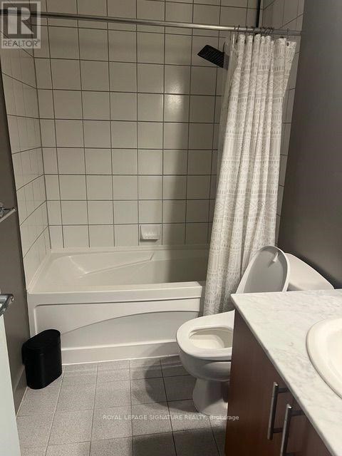 A white bathroom with a toilet, sink, and bathtub.