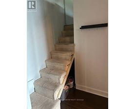 A staircase with a carpeted runner and a wooden handrail.