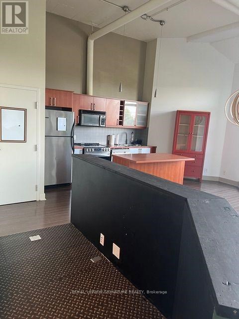 A kitchen area with a black counter and a fridge.