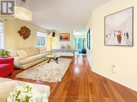 A living room with a white couch and a painting on the wall.