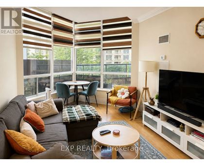 A living room with a grey couch, a coffee table, and a television.