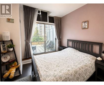 A bedroom with a large bed and a window with curtains.