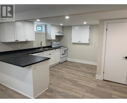 A kitchen with white cabinets and a black countertop.