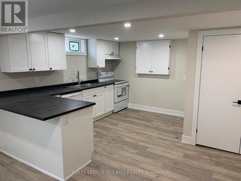 A kitchen with white cabinets and a black countertop.