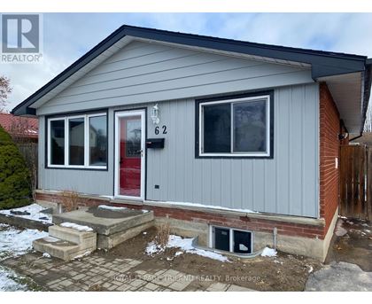 A grey house with a red door and a number 62 on it.