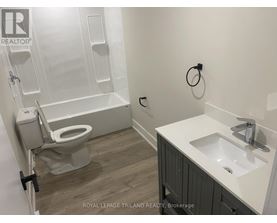 A white sink is on a counter next to a toilet.