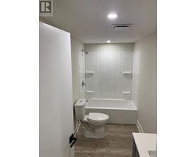 A white bathroom with a toilet, sink, and bathtub.