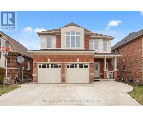 A large, two-story house with a garage is for sale.