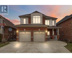 A house with a garage and a driveway in front of it.