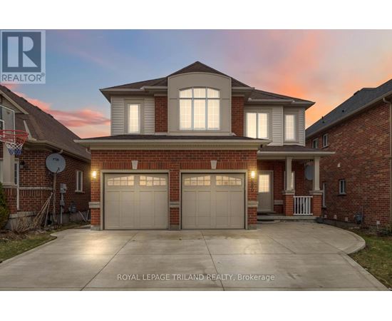 A house with a garage and a driveway in front of it.