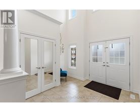 A white hallway with a black rug and a blue chair.