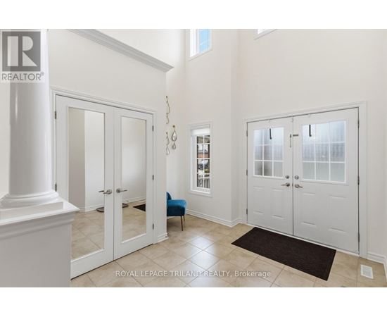 A white hallway with a black rug and a blue chair.