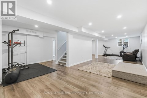 A spacious room with a black exercise bike and a black chair.