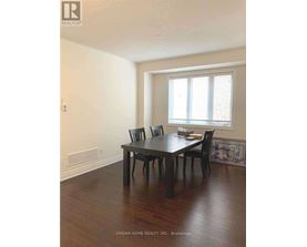 A dining room with a table and chairs.