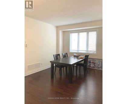 A dining room with a table and chairs.